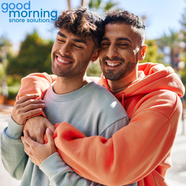 Two men embracing each other and smiling