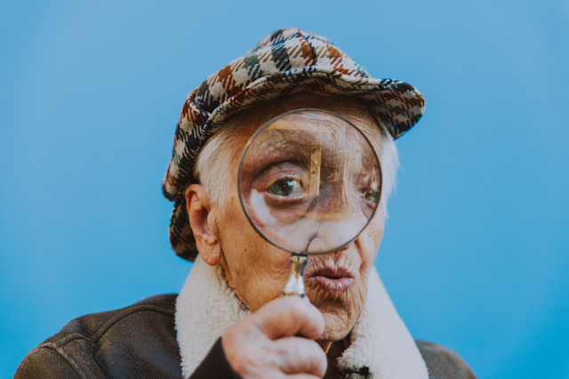 older lady holding magnifying glass