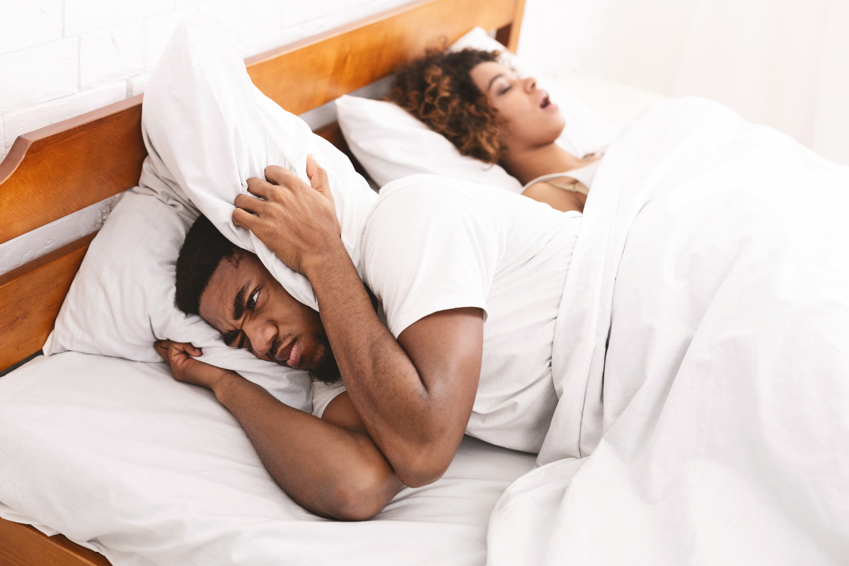Man and women in bed, woman is snoring