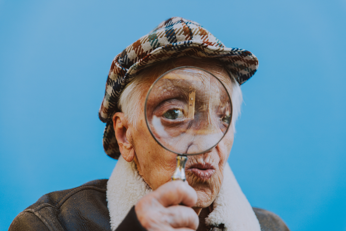 Elderly looking detective with magnifying glass