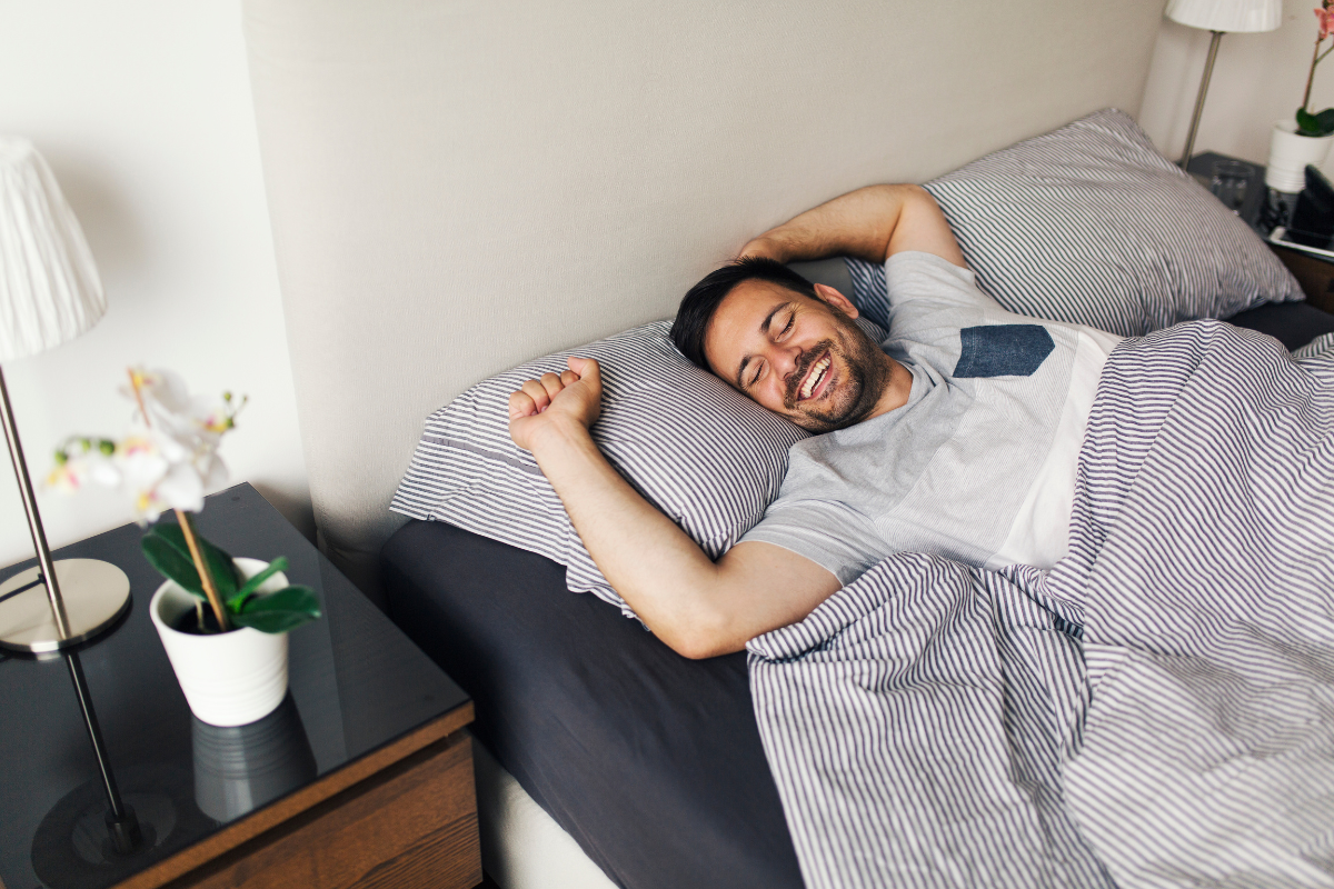 Happy guy sleeping in bed