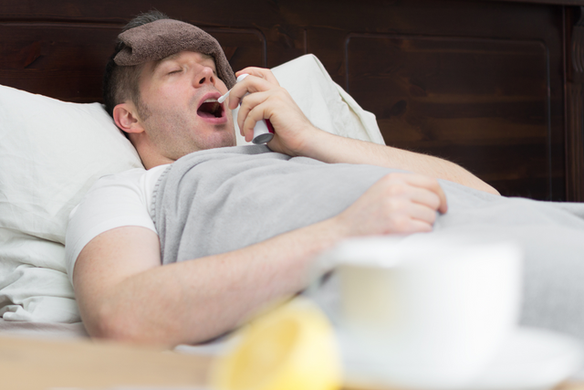 Man spraying antisnore spray in mouth