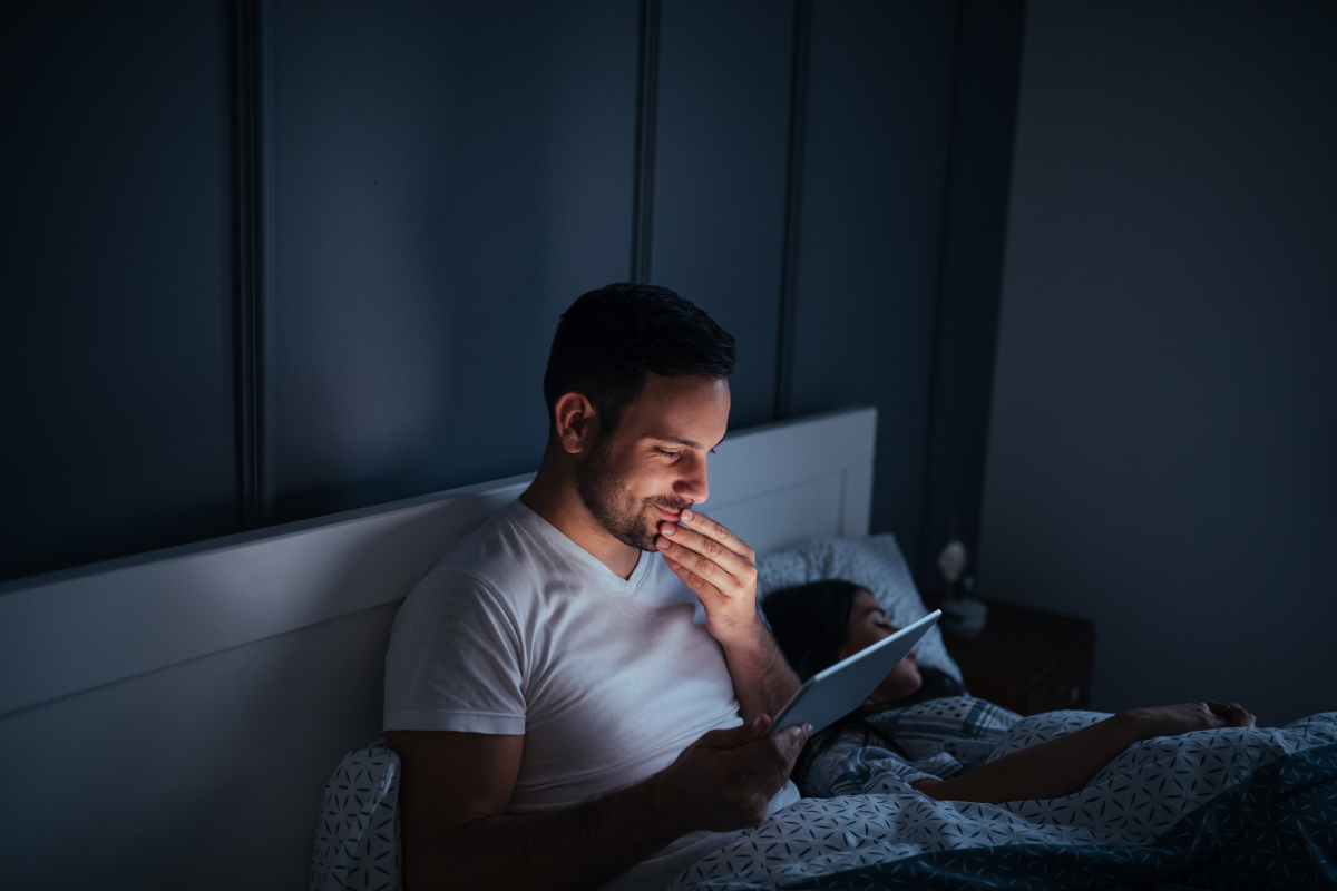 man reading computer in bed