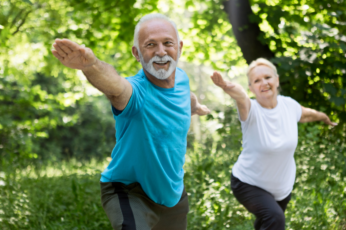 Older couple doing yoga outdoors