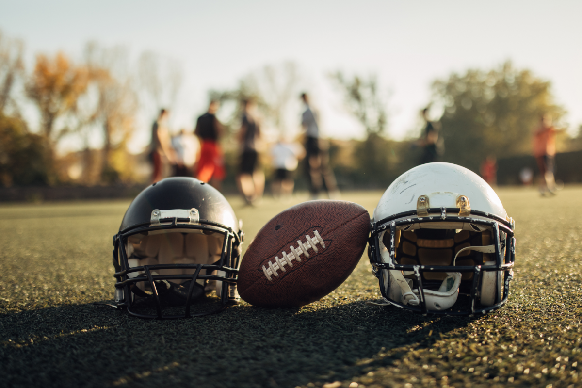 two helmets and football and fall season field
