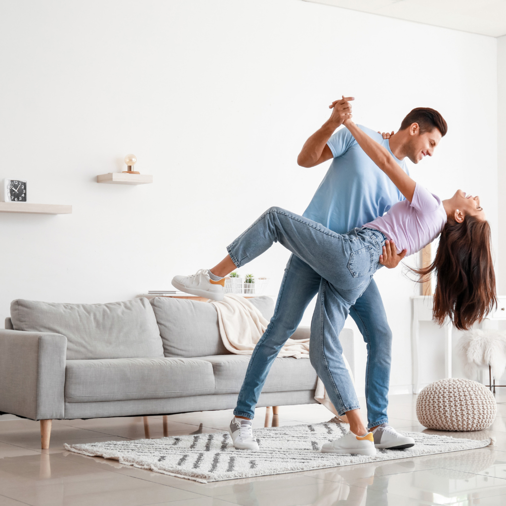 a young couple in a living room dancing